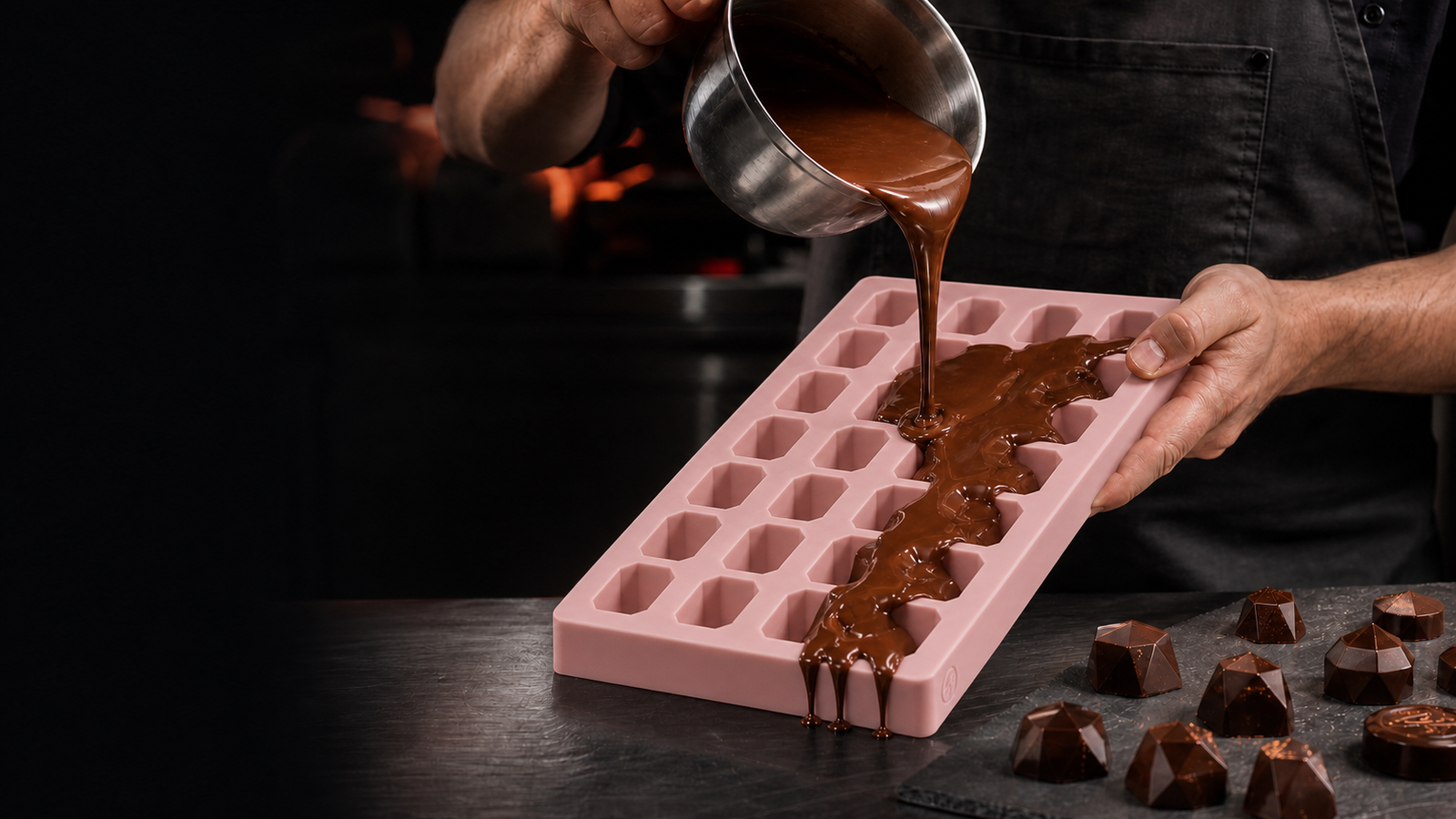 Chocolatier versant naturellement du chocolat dans un moule à pralines en silicone épais